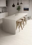 Blossom Taupe Matt Porcelain Tile flooring in modern kitchen design with island and bar stools.