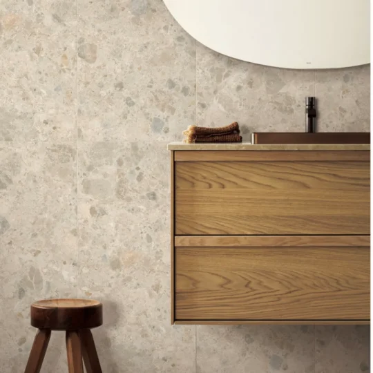 Middle Grey Stone Look Porcelain Tile installed in bathroom setting with vanity and stool.